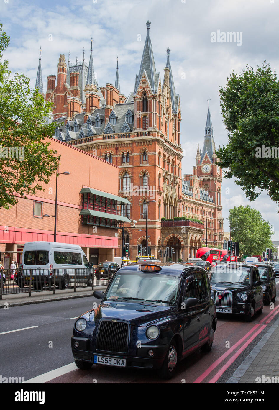 Nero, Londra taxi in coda sulla Euston Road con architettura gotica del St Pancras International Hotel dietro. Foto Stock