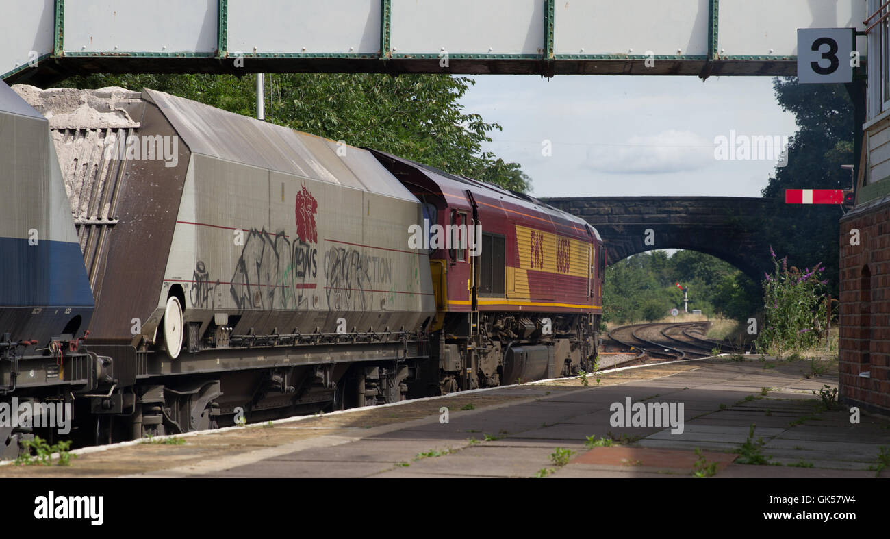 DB Cargo Classe 66 locomotiva diesel lavora un treno di tramoggia vuota (carri utilizzati per il trasporto di sabbia) alla stazione Helsby, Cheshire Foto Stock