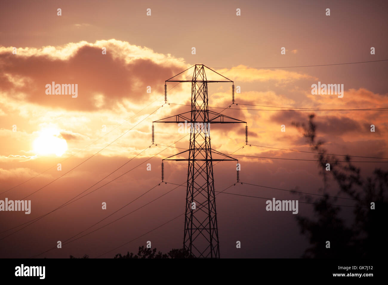 Elettricità tralicci e linee di potenza ar crepuscolo con un moody sky ambientali Foto Stock