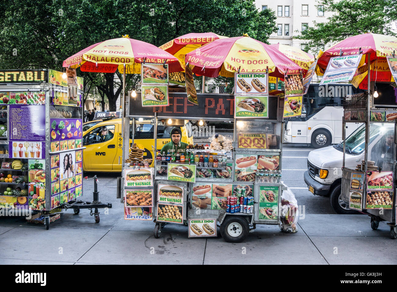 File colorate di fornitori carri stipati di Fifth Avenue cordolo nella parte anteriore del GM edificio plaza dove molte persone che soffrono la fame mangiare il pranzo Foto Stock