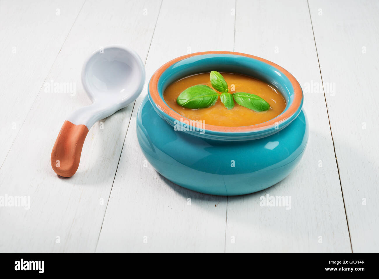 Fresca zuppa di zucca in ceramica ciotola con cucchiaio su un vecchio sfondo di legno Foto Stock