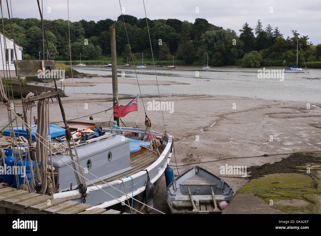 Barca a vela ormeggiata lungo il fiume Deben di Woodbridge nel Suffolk, Inghilterra Foto Stock