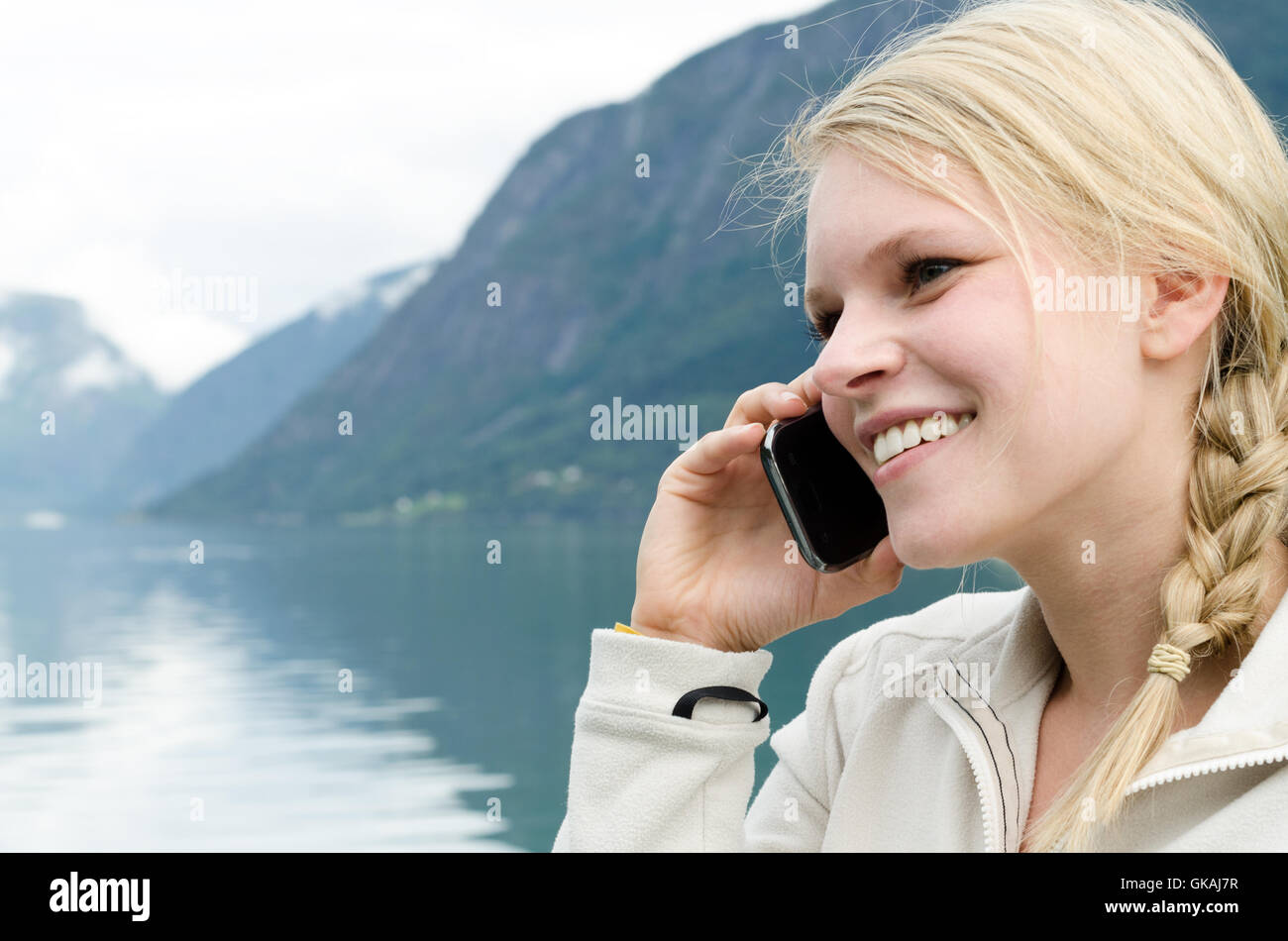 Giovane donna bionda al telefono con il suo smartphone Foto Stock