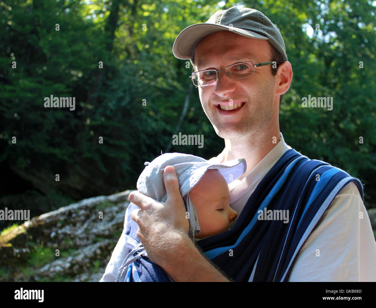 Padre che porta il figlio in una fionda Foto Stock