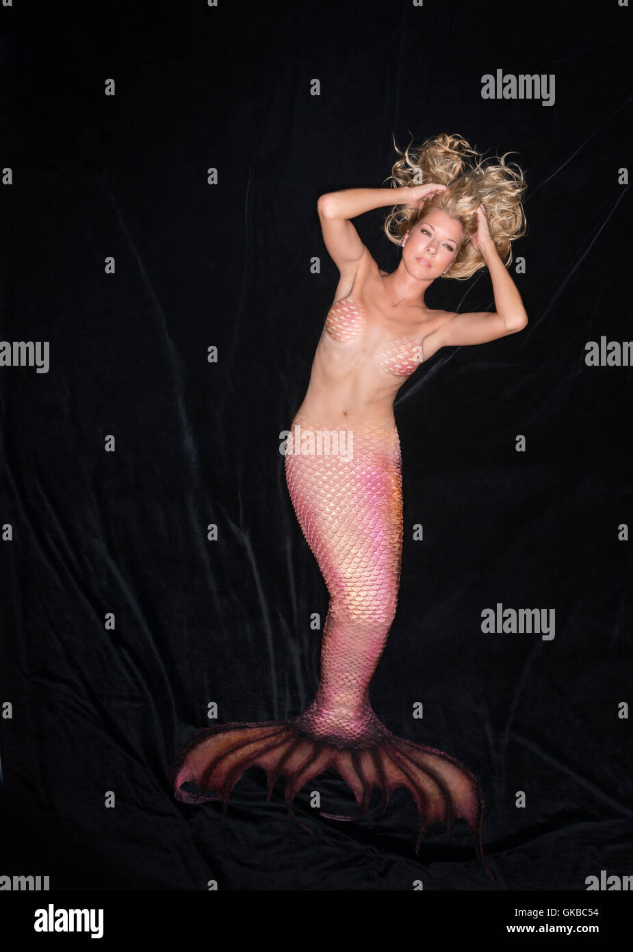 Blonde mermaid posa sul velluto nero in studio, Virginia Beach, Foto Stock