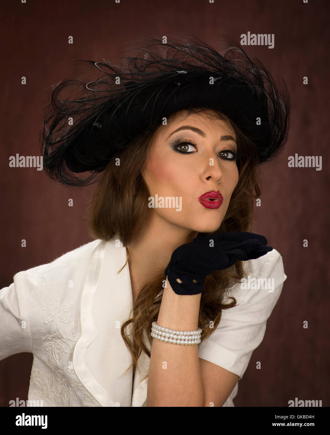 Bruna giovane donna della modellazione di un vintage black hat Foto Stock