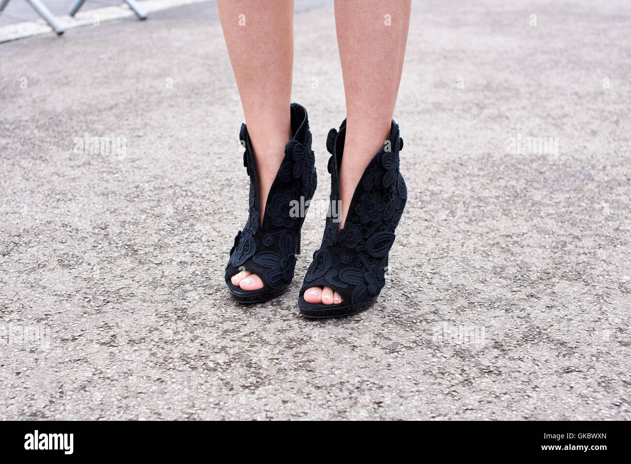 Donna in piedi in strada di indossare tacchi alti, dettaglio Foto Stock