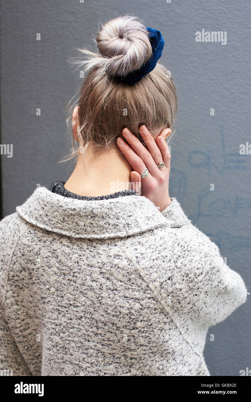 Vista posteriore di una donna con capelli fino in un panino, verticale Foto Stock