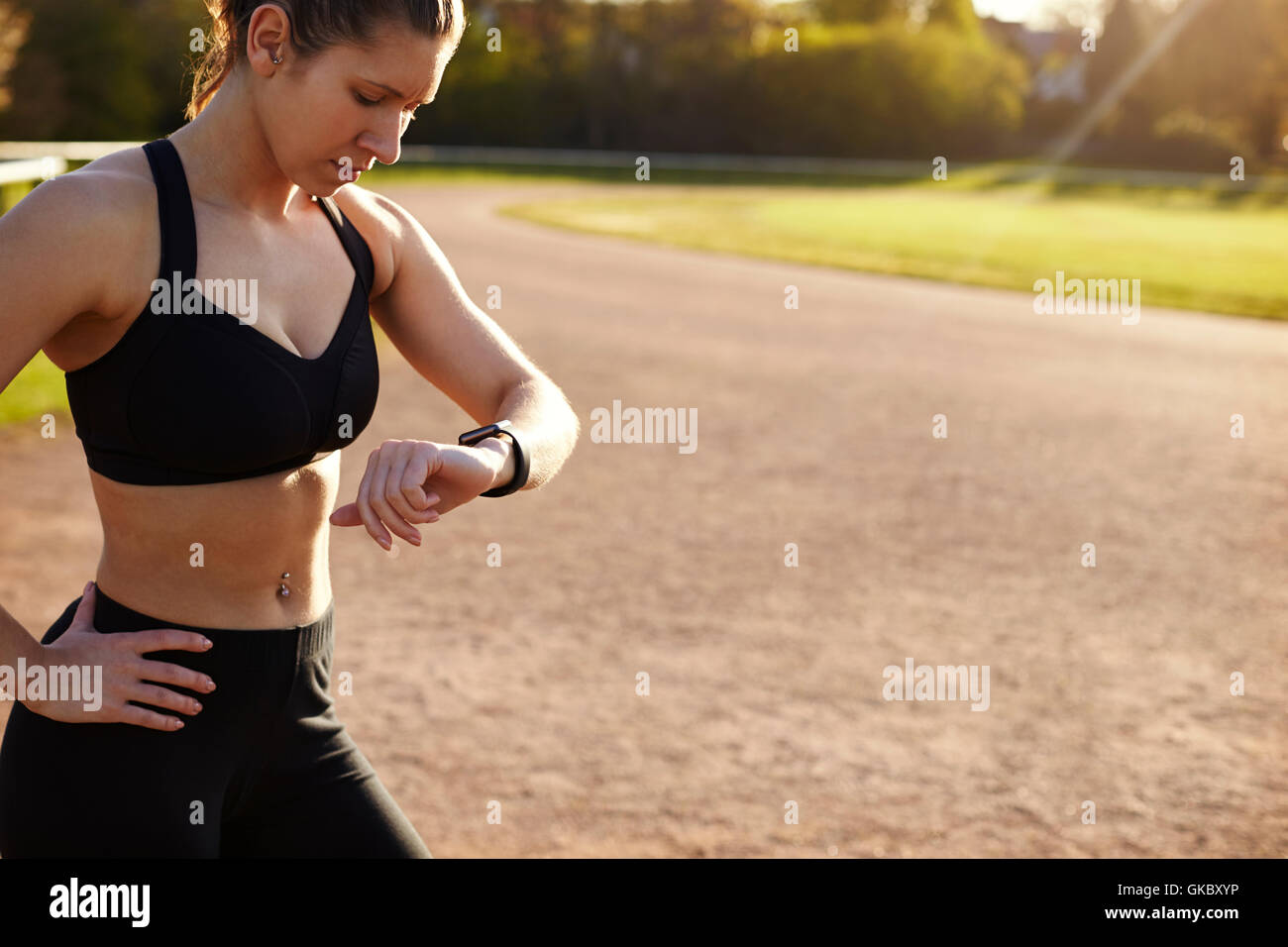 Giovane donna controlli Tracker attività durante l'esercizio per esterni Foto Stock
