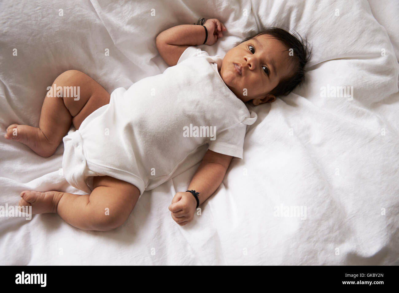 Guardando verso il basso sulla Happy Baby Boy giacente sul letto Foto Stock