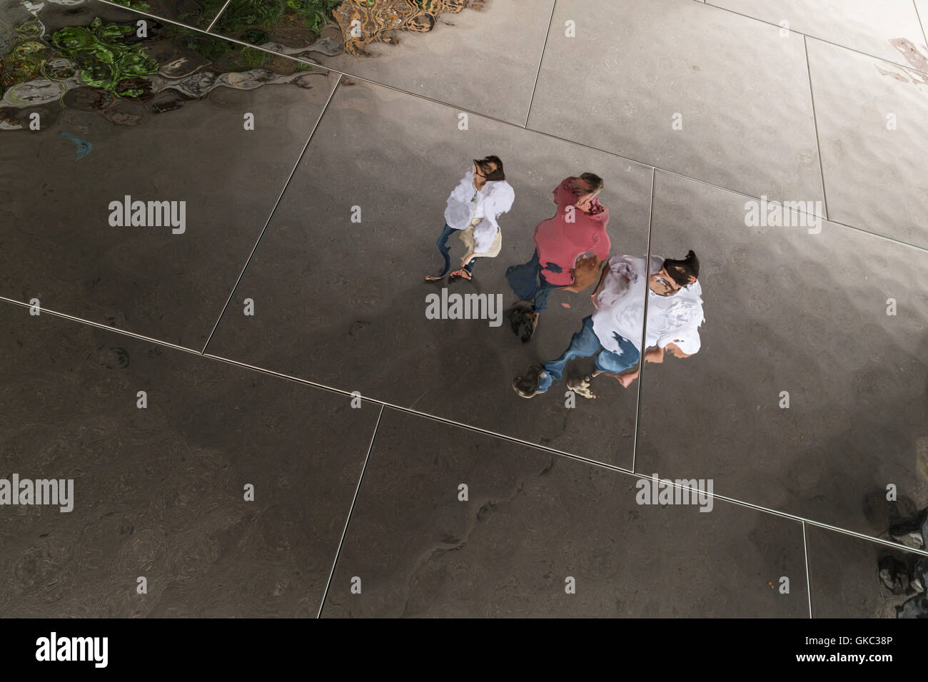 Contorte riflessioni di persone in un soffitto con specchi Foto Stock