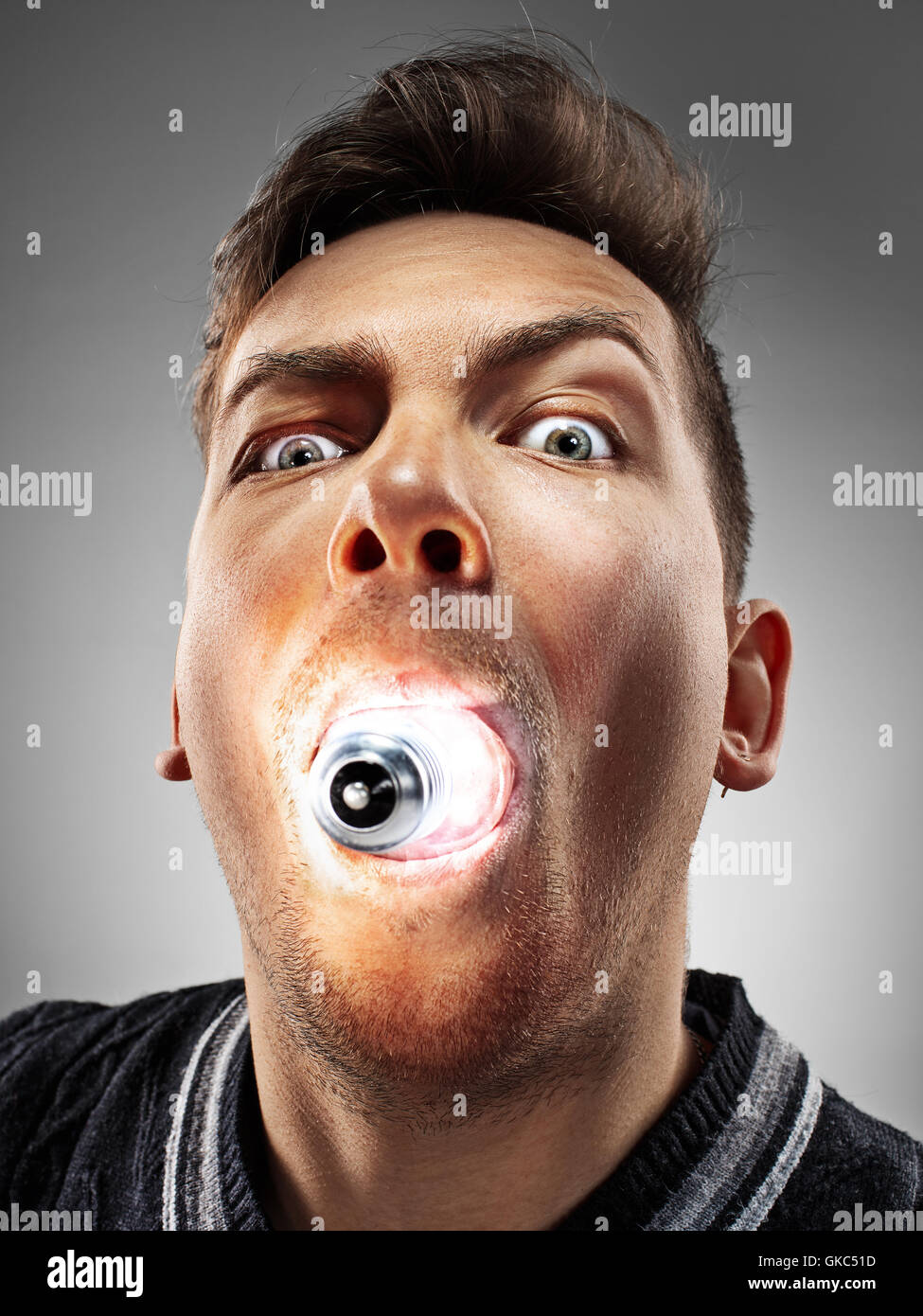 Il simpatico uomo caucasico con lampadina incandescente nella sua bocca su  sfondo grigio Foto stock - Alamy