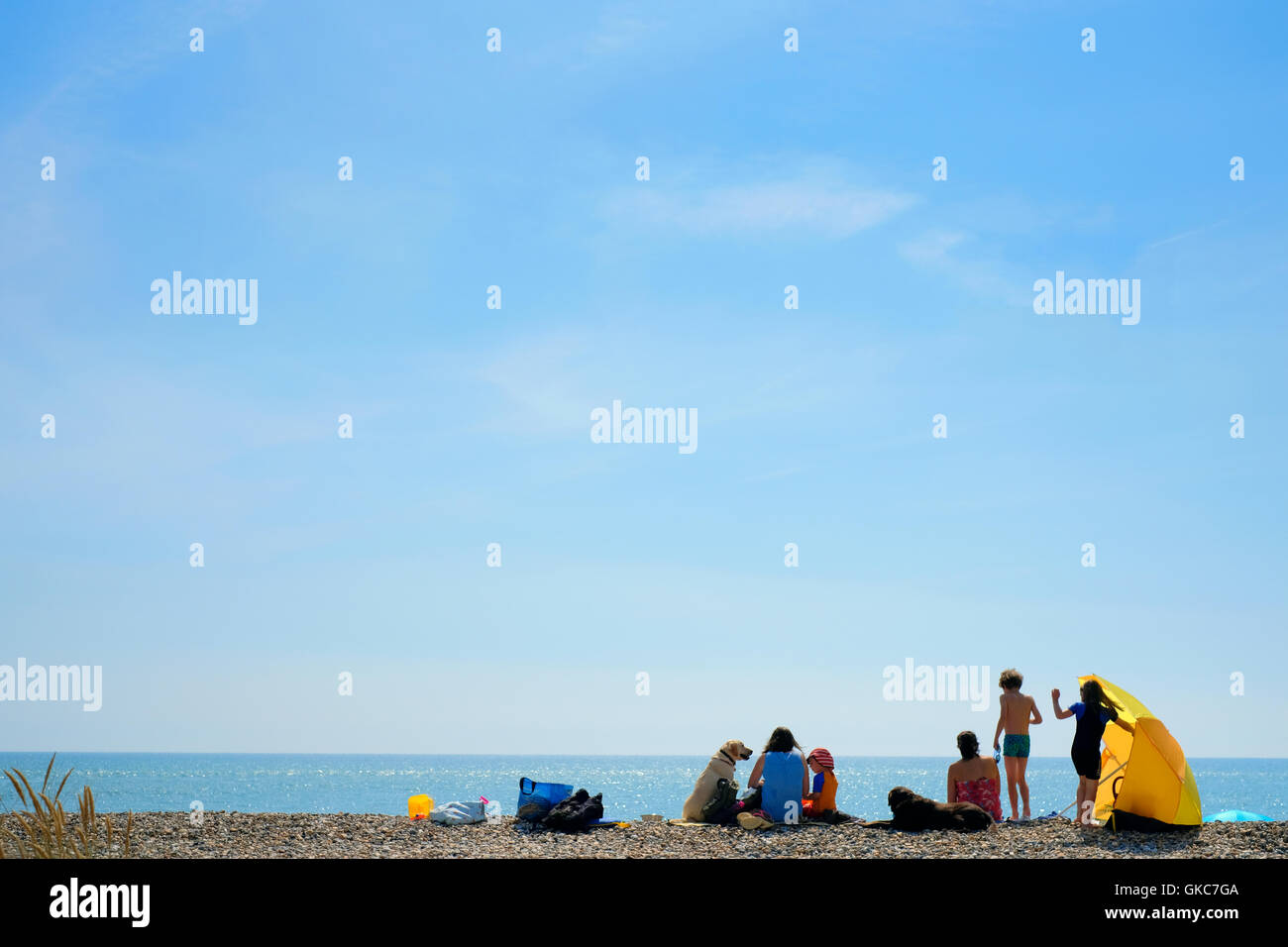 Giovani famiglie che godono di una giornata di estati sulla spiaggia sulla costa inglese - UK staycation estate spiaggia vacanza - banca vacanza - scuole fuori Foto Stock