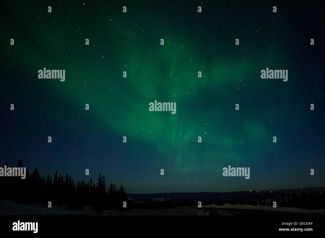 Fasce verdi di un aurora riempiono il cielo Foto Stock