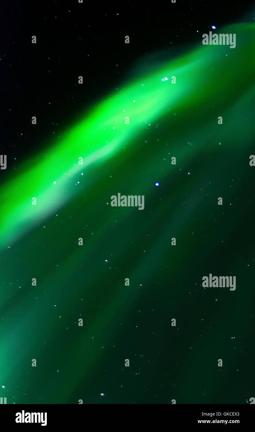 Il bagliore verde di un aurora sorge come una cortina fino al cielo. Foto Stock