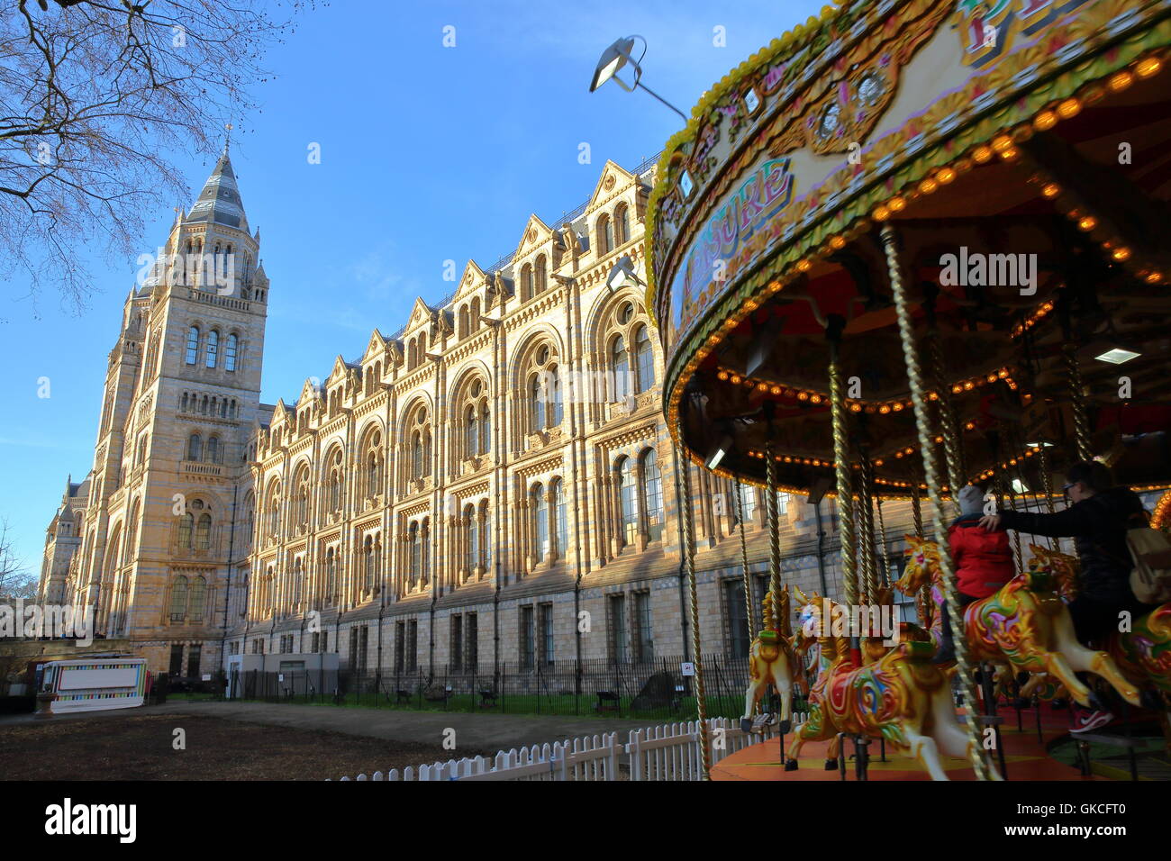 Il museo di storia naturale in inverno con un regalo di Natale per i bambini nella giostra in primo piano, Londra, Gran Bretagna Foto Stock