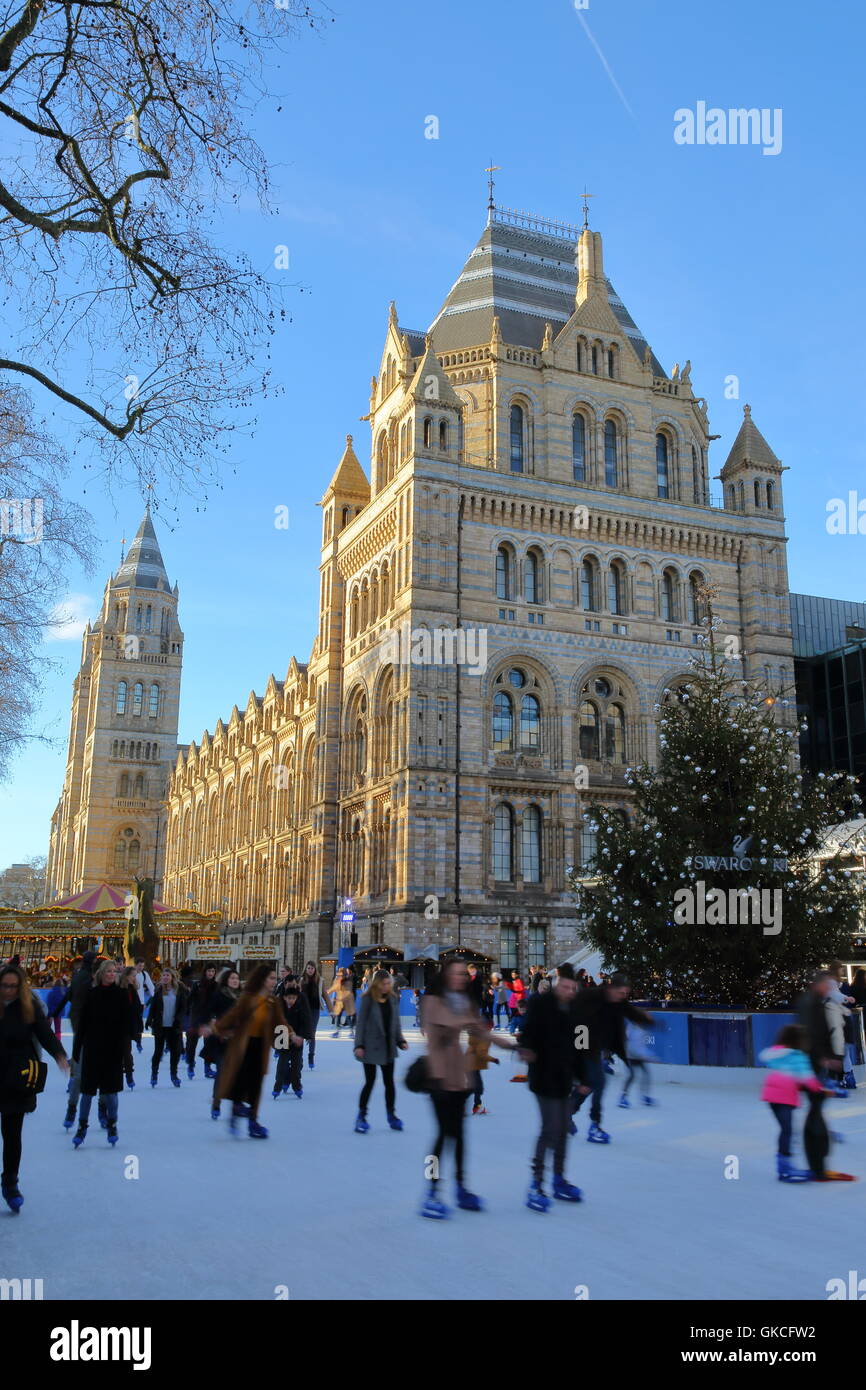 Il museo di storia naturale in inverno con persone di pattinaggio in primo piano, Londra, Gran Bretagna Foto Stock