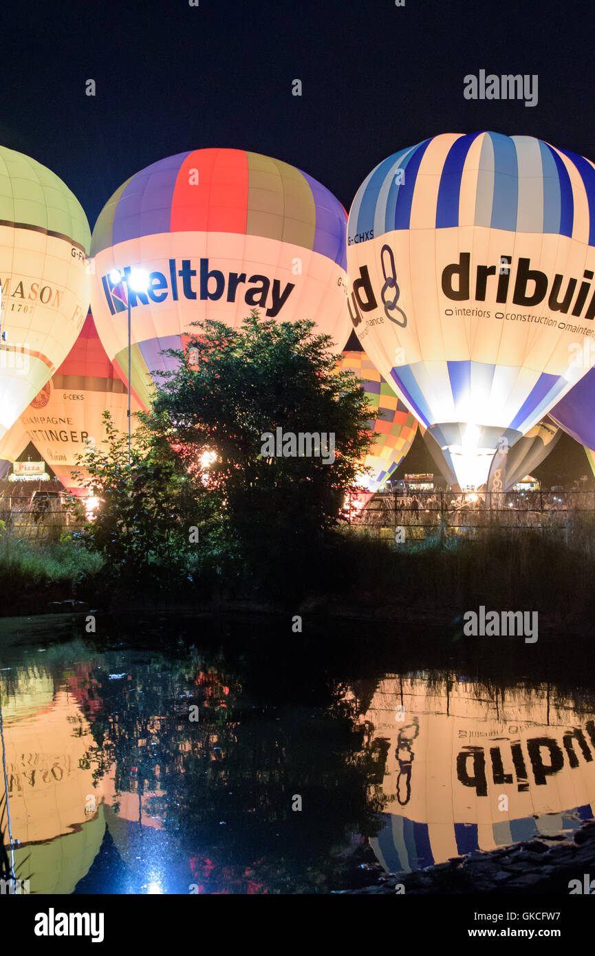 Bristol Balloon Fiesta night display incandescenza riflettendo in un stagno Foto Stock