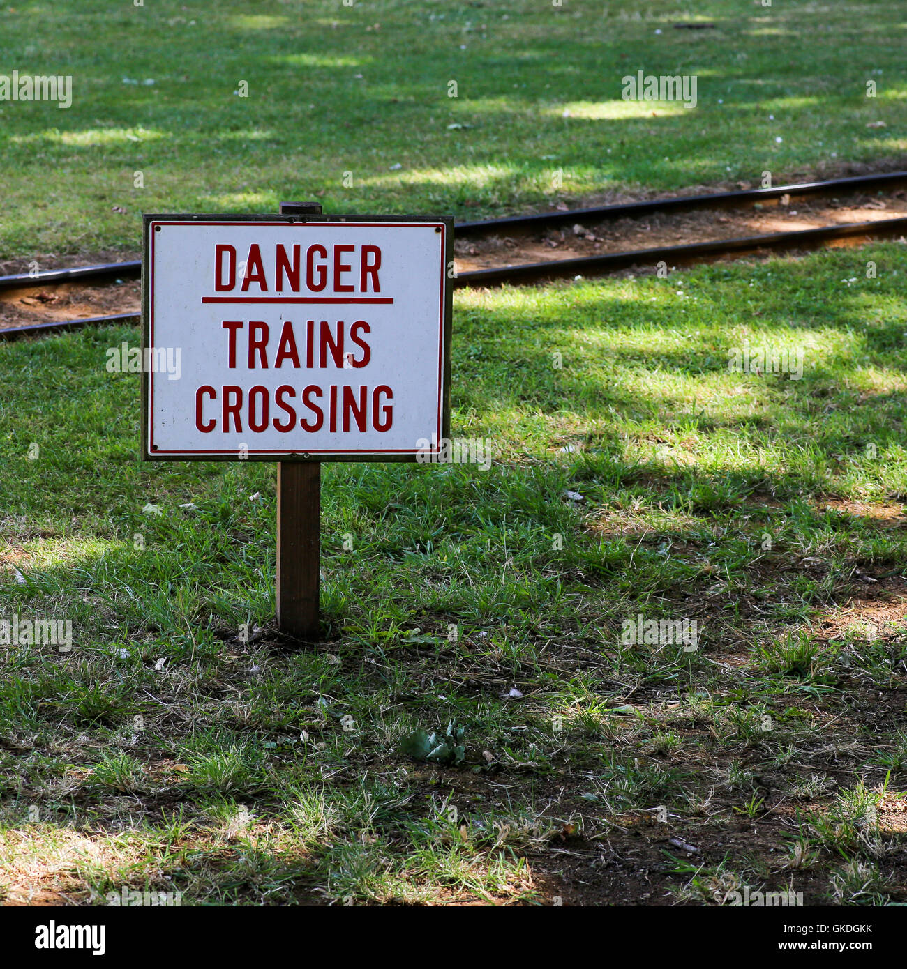 Avviso di pericolo segno accanto ad un giardino zoologico della ferrovia di consigliare ai pedoni di prestare attenzione Foto Stock