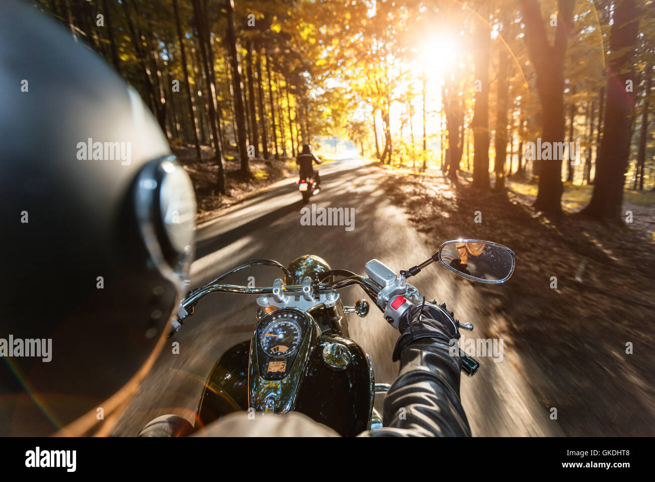 I driver del motociclo equitazione sulla autostrada nella splendida luce del tramonto. Colpo da pillion vista driver Foto Stock