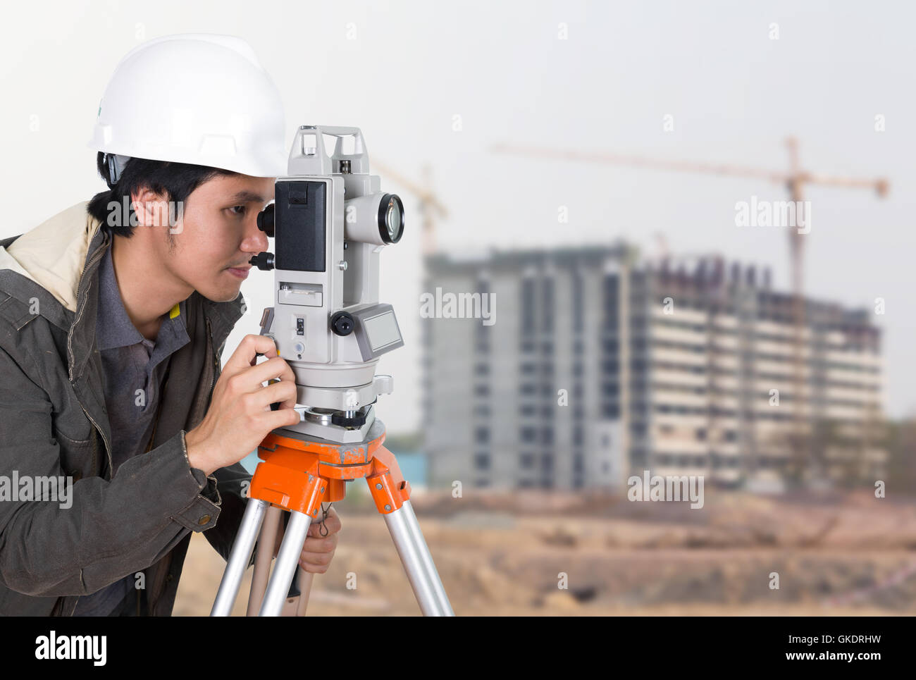 I tecnici utilizzano tacheometer o teodolite con la costruzione di edifici di sfondo del sito Foto Stock