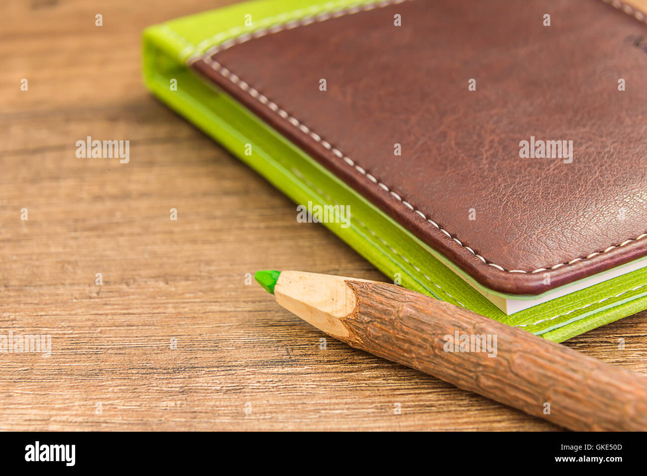 Verde matita in legno marrone e verde eserciziario in pelle Foto Stock