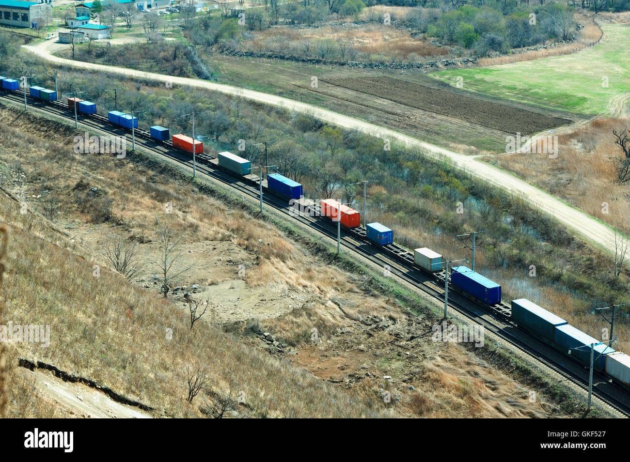 Treno merci in movimento lungo su uno sfondo di colore verde valle di primavera Foto Stock