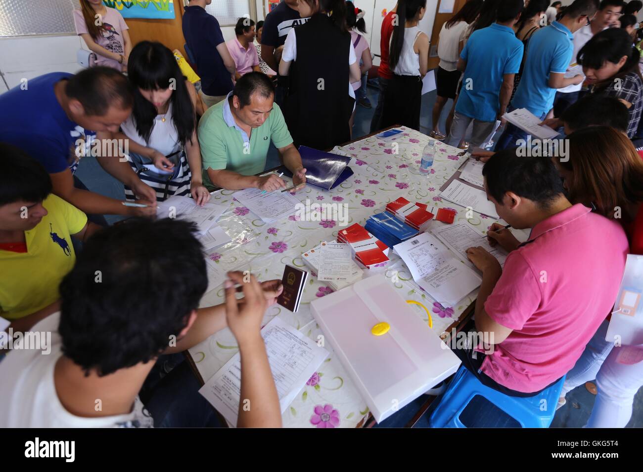 Cattania, Italia. 19 Ago, 2016. Overseas Chinese compilare moduli in Cattania, Italia, Agosto 19, 2016. Tre diplomatici dall'Ufficio Consolare dell'ambasciata cinese a Roma è venuto a Cattania Venerdì, fornendo servizi per l'Overseas Chinese. © Luo Na/Xinhua/Alamy Live News Foto Stock