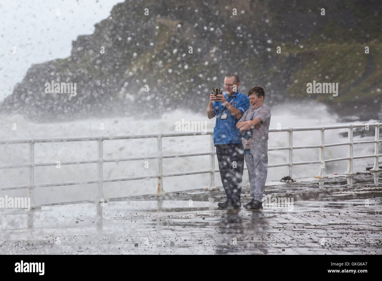 Aberystwyth, Wales, Regno Unito. Il 20 agosto 2016. Regno Unito meteo. Unseasonably alta venti fino a 48 mph si combinano con una molla di alta marea per generare onde enormi rizzatura Aberystwyth Promenade. I fotografi e gli scuotipaglia sono catturati fuori. Credito: Alan Hale/Alamy Live News Foto Stock