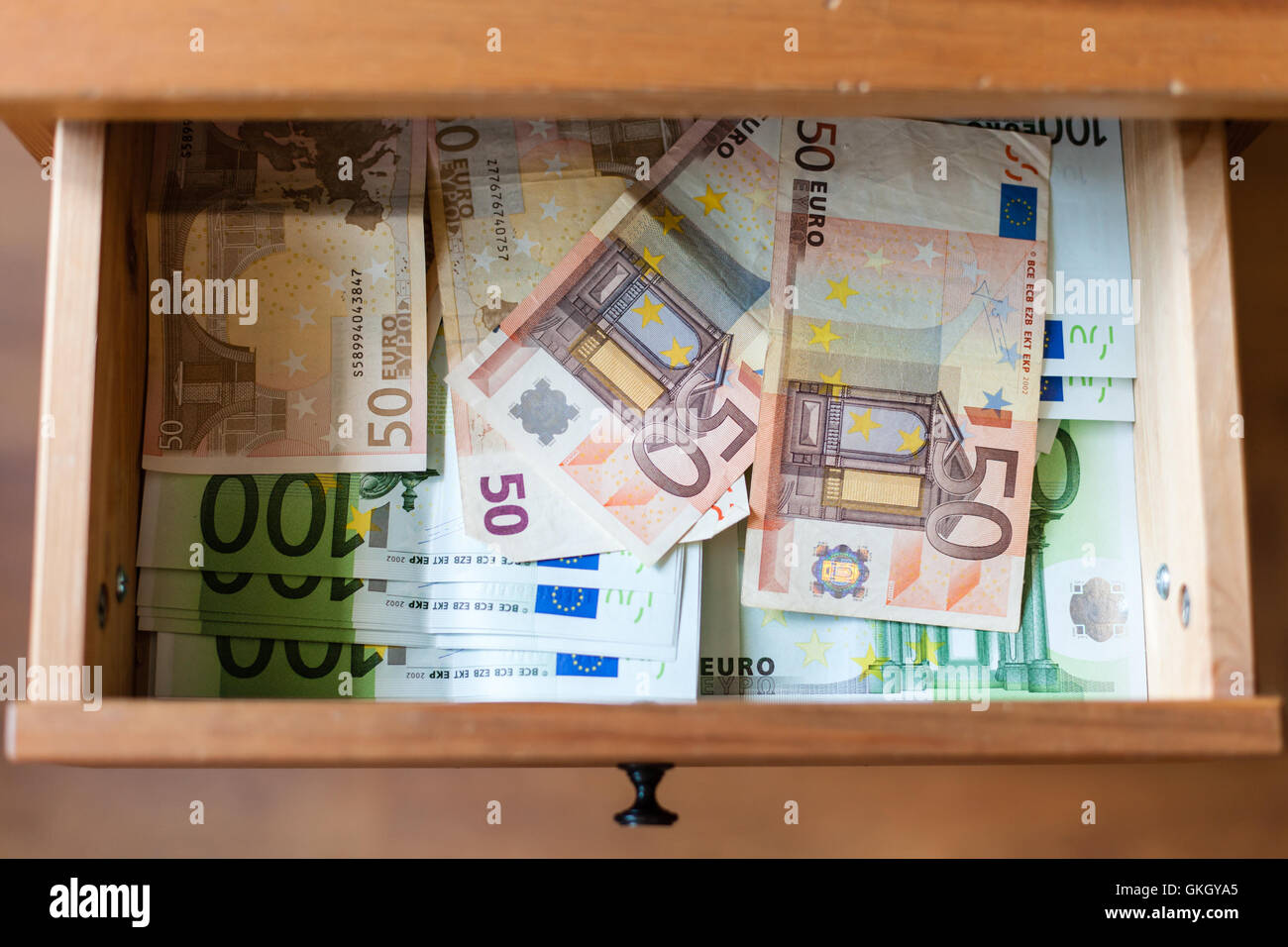 Vista al di sopra di molte delle banconote in euro sul fondo di aprire il cassetto del comodino Foto Stock
