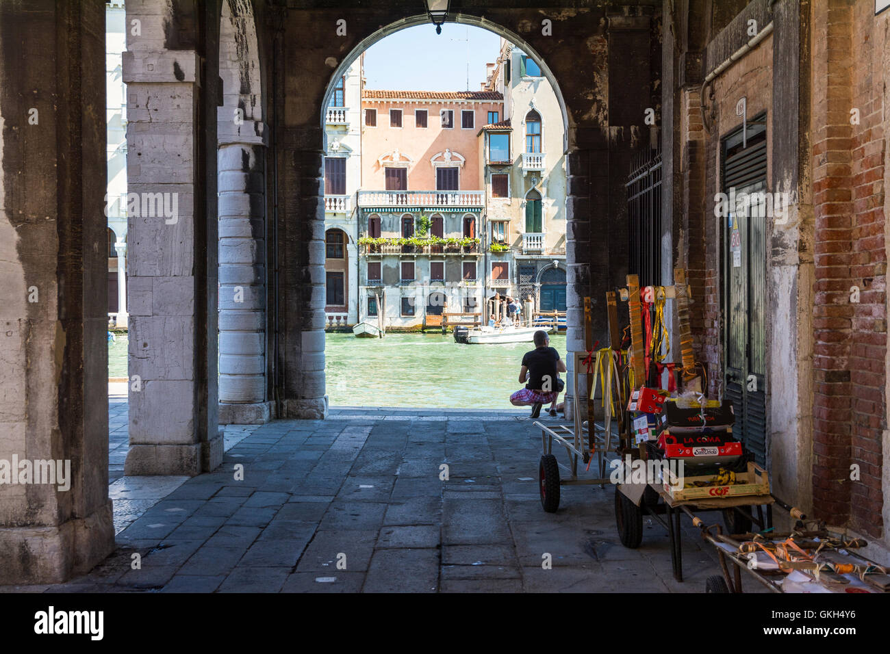 Venezia,Italy-August 17,2014:visualizzazione di hte uomo che guarda il Canal Grande dal portico vicino al Ponte di Rialto durante una giornata di sole. Foto Stock