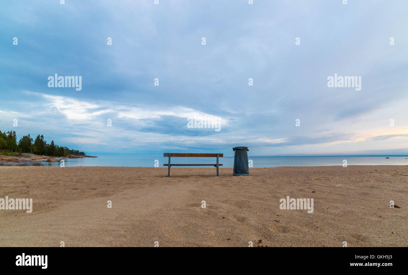Panca e nel Cestino sulla spiaggia da oceano. Foto Stock