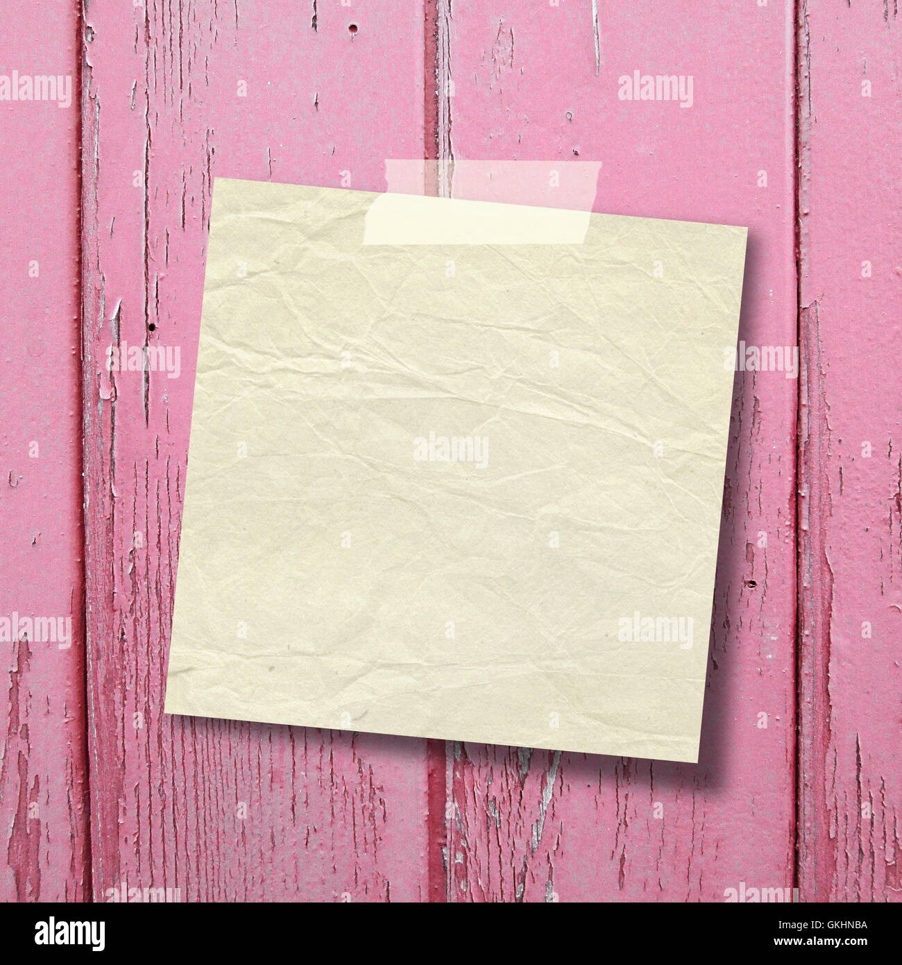 Close-up di un quadrato bianco il vecchio foglio di carta telaio con nastro adesivo rosa su tavole di legno sfondo Foto Stock