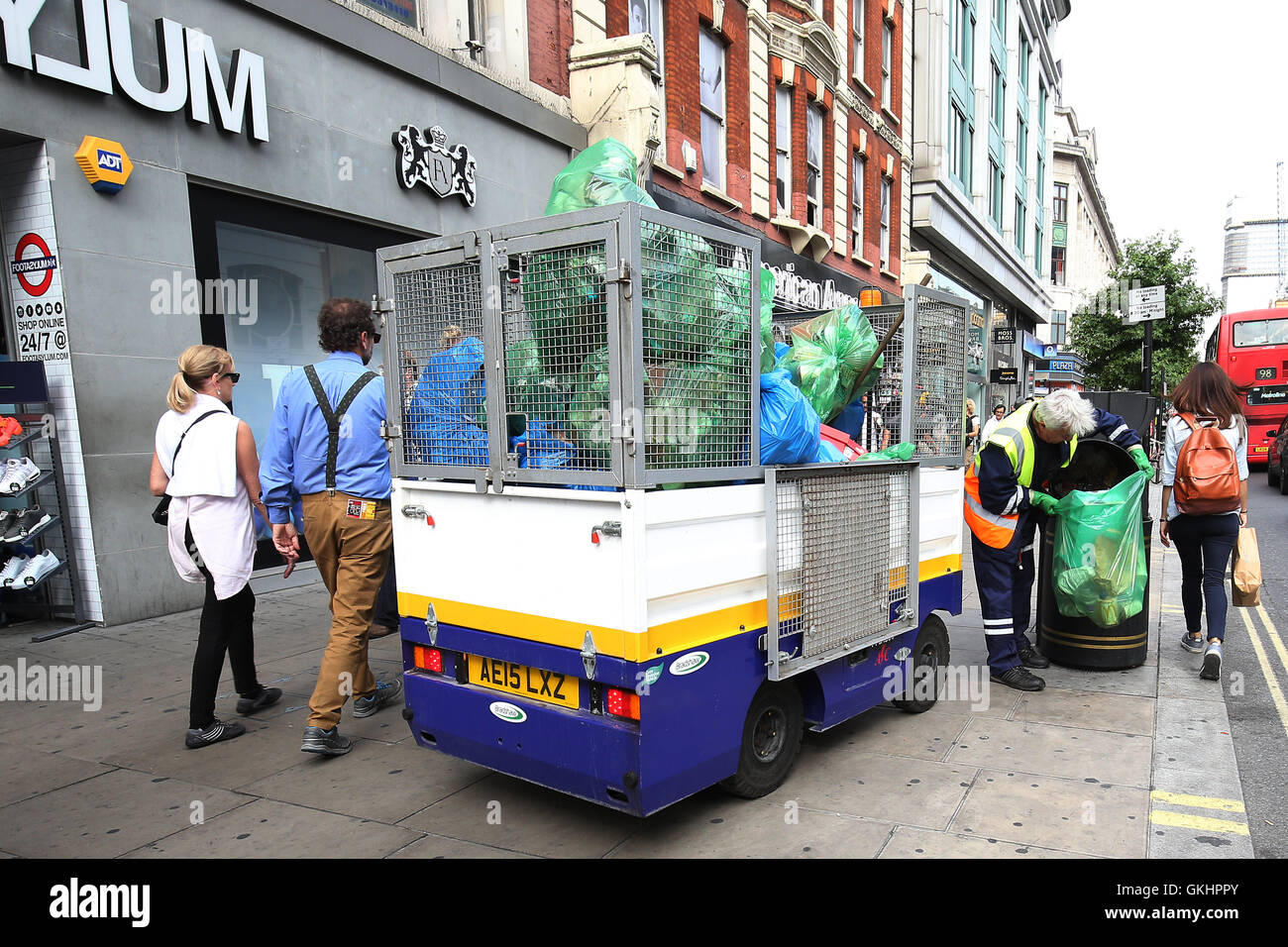 Regno Unito, Londra : un pulitore di via svuotamento di un cassonetto Oxford Street nel centro di Londra il 20 agosto 2016. Foto Stock