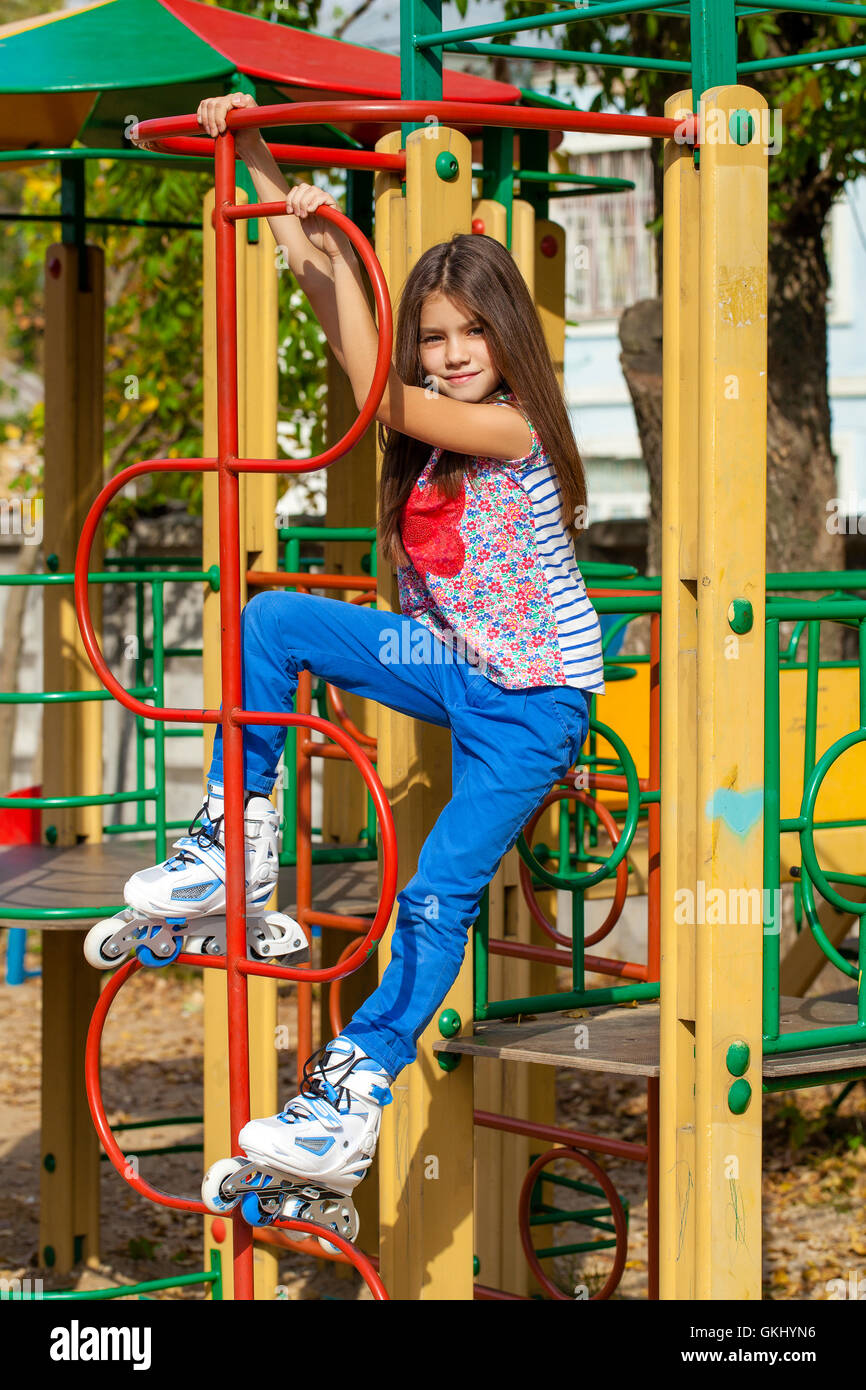Ritratto di una decina di anni di ragazza di un parco giochi in pattini a rotelle Foto Stock