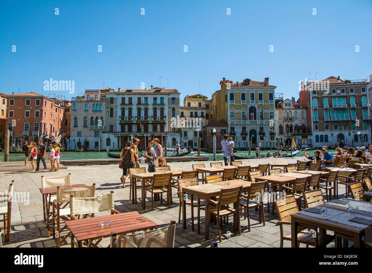 Venezia,Italy-August 17,2014:persone passeggiare a piedi o prendere un periodo di riposo vicino al bar e ristorante sul Canal Grande vicino al Ponte di Rialto duri Foto Stock