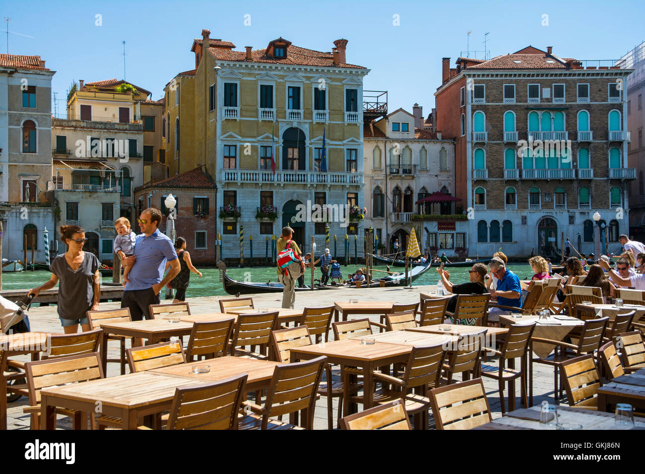 Venezia,Italy-August 17,2014:persone passeggiare a piedi o prendere un periodo di riposo vicino al bar e ristorante sul Canal Grande vicino al Ponte di Rialto duri Foto Stock
