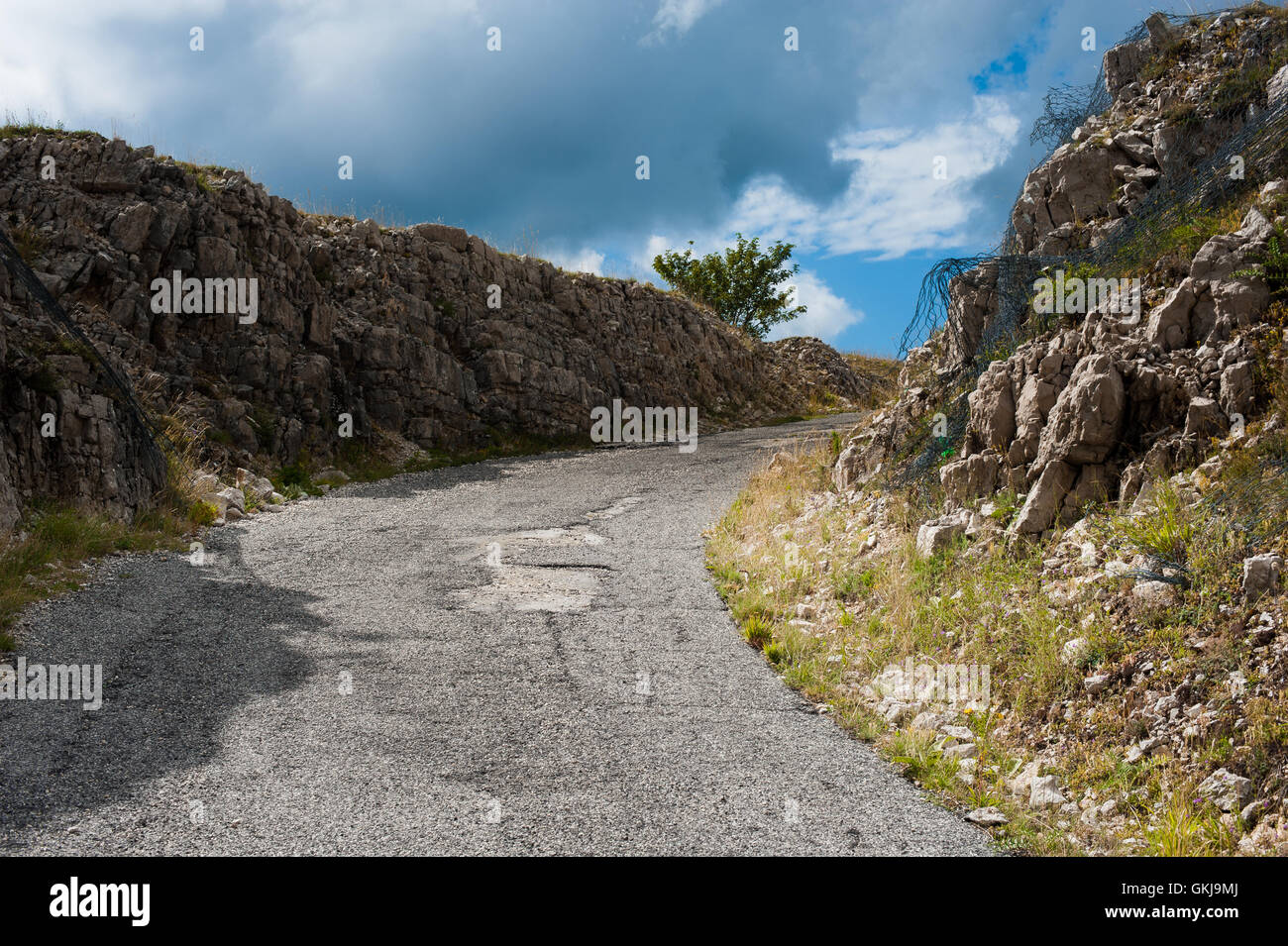 Percorso stradale per l'ignoto tra muri di pietra, il modo per raggiungere la parte superiore Foto Stock