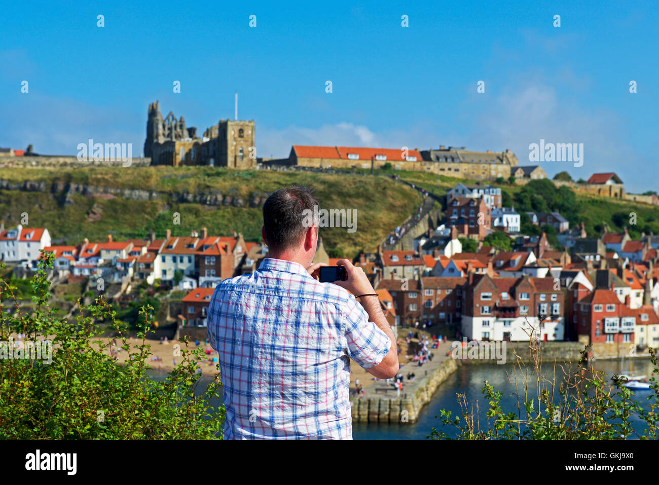 Uomo di fotografare il porto, Whitby, North Yorkshire, Inghilterra, Regno Unito Foto Stock