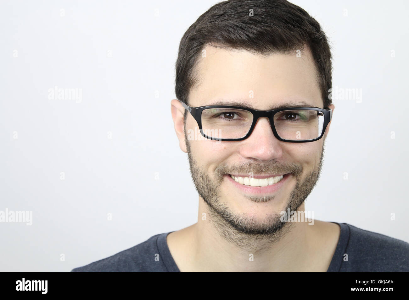 Uomo bello che indossano occhiali sorridente Foto Stock