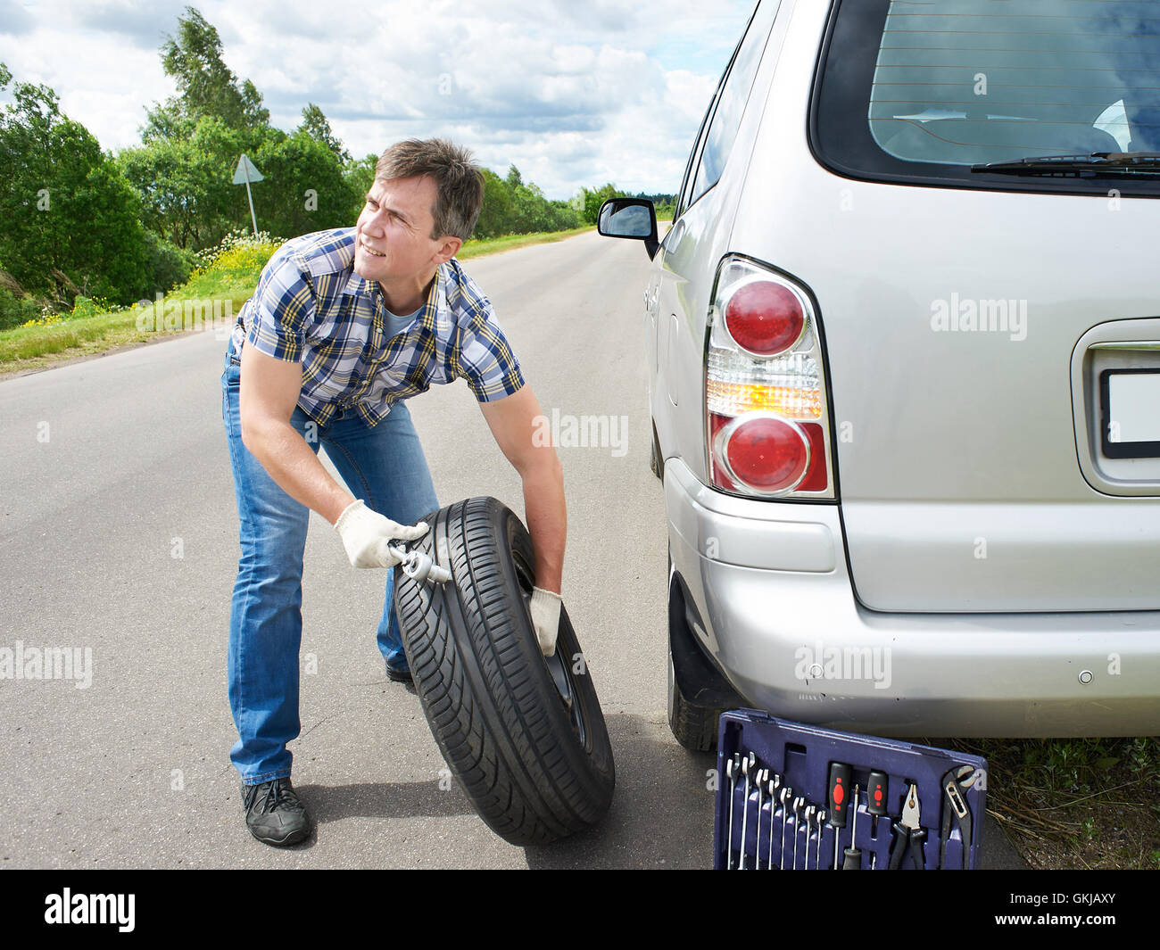 L Uomo Cambiare Una Ruota Della Macchina Su Strada Foto Stock Alamy