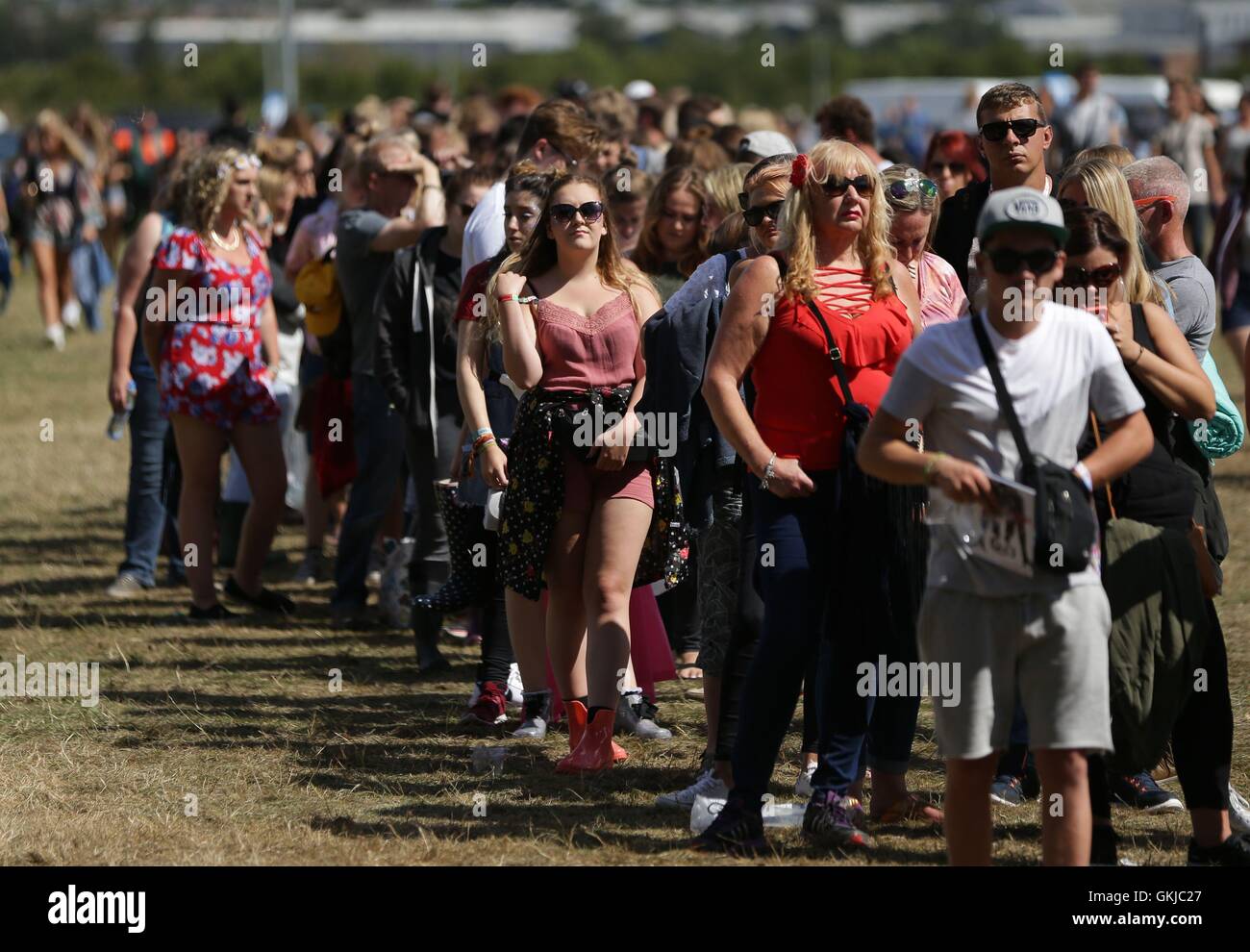 I frequentatori del festival di arrivare al V Festival a Hylands Park a Chelmsford Essex. Foto Stock