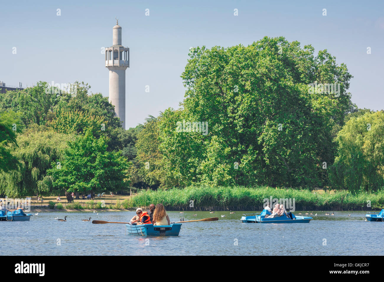 Londra musulmana, vedere in estate i turisti in barche sul lago in barca nel Parco del Regent's con il minareto della moschea sullo sfondo, Londra, Regno Unito. Foto Stock