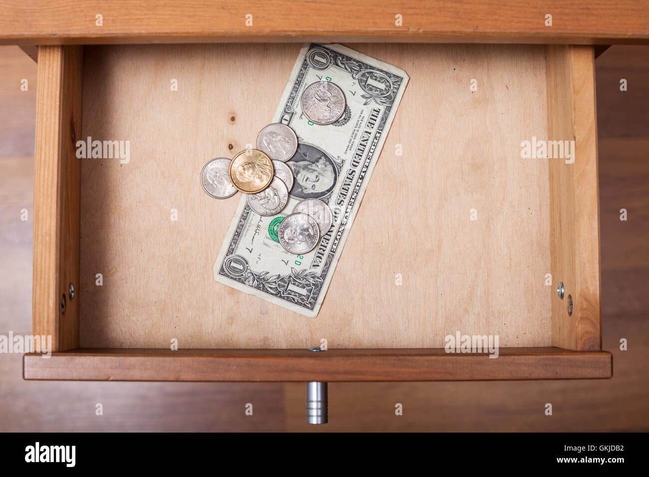 Vista dall'alto di un dollaro e monete in aprire il cassetto del comodino Foto Stock