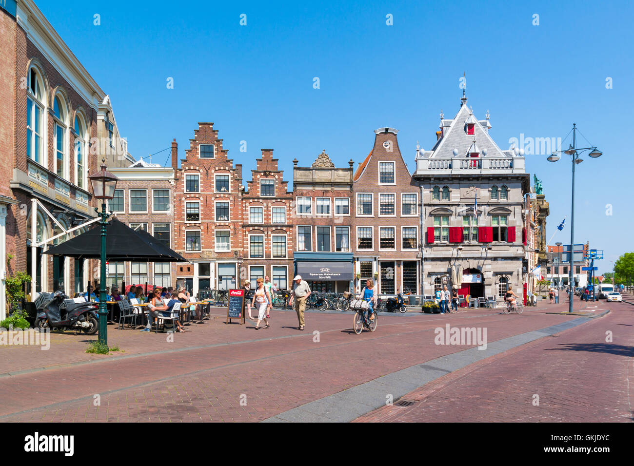 La gente a piedi e in bicicletta in Damstraat e Spaarne con facciate delle vecchie case e Waag a Haarlem, Olanda, Paesi Bassi Foto Stock