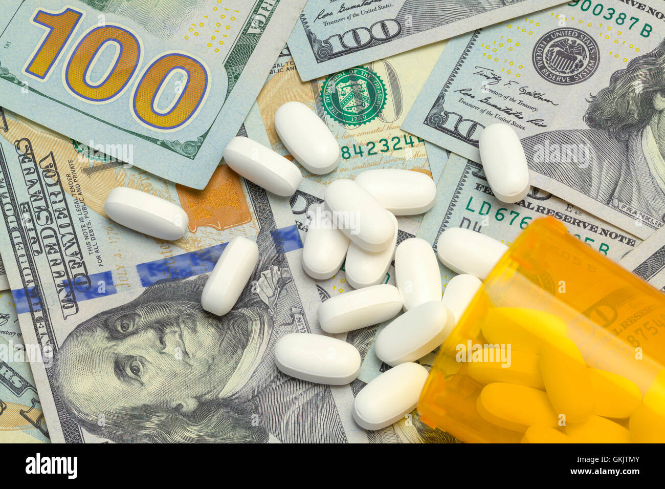 Eventuali fuoriuscite di Bottiglia di pillole sulla sommità di una pila di denaro. Foto Stock