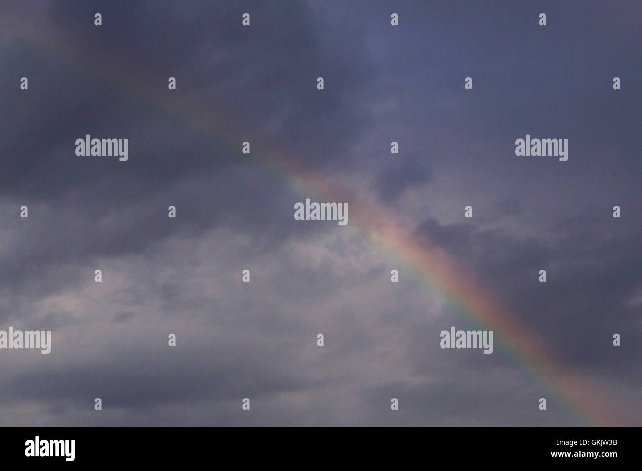 L'arcobaleno in un cielo di nuvole scure Foto Stock