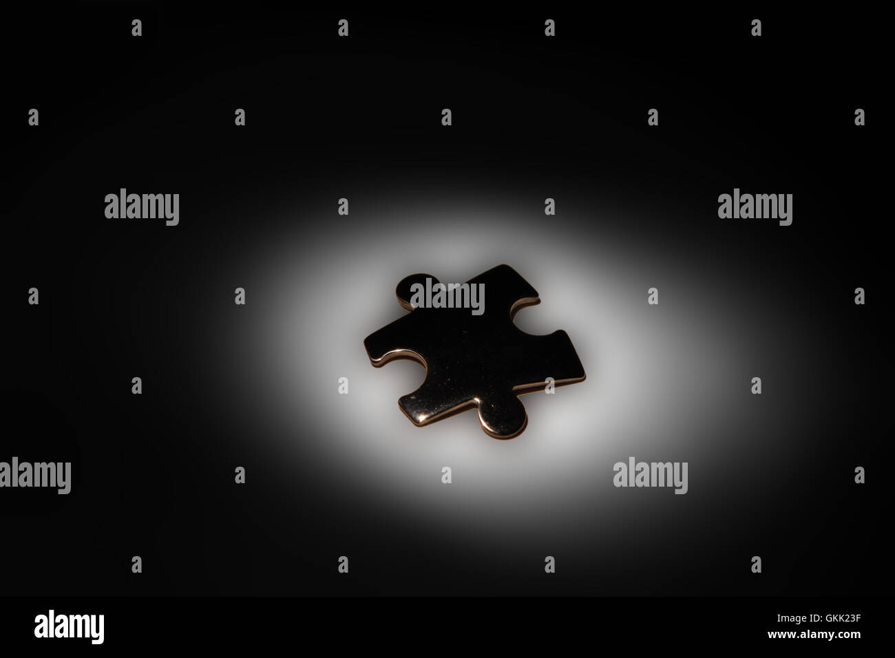 Cromato singolo pezzo del puzzle in Spotlight su sfondo nero Foto Stock