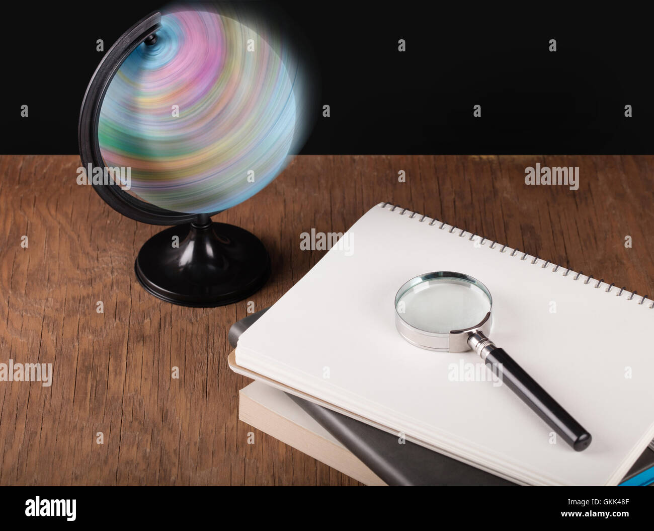 Globo rotante e notebook con una lente di ingrandimento Foto Stock