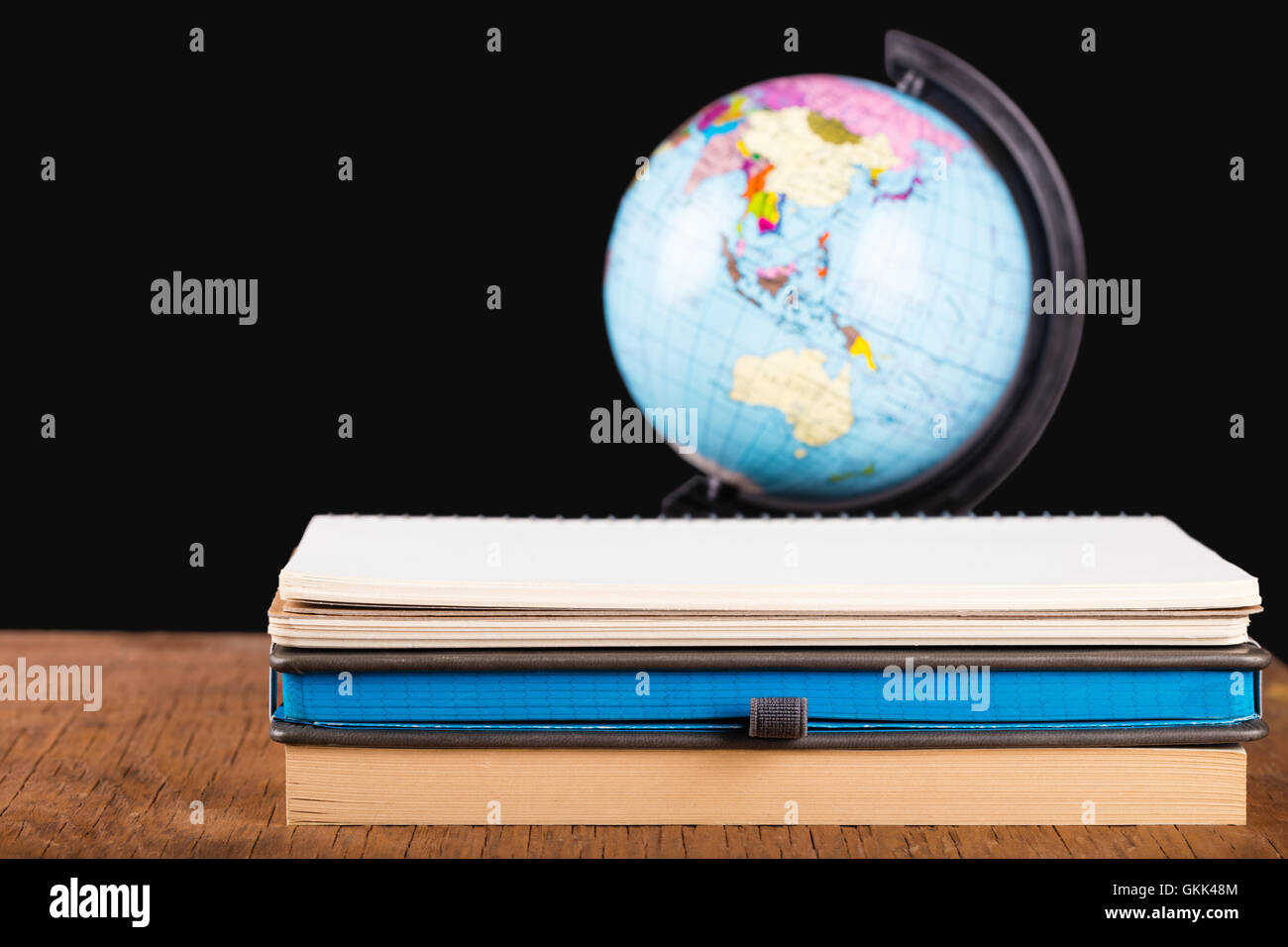 Quaderni di close-up e il mondo su uno sfondo nero Foto Stock